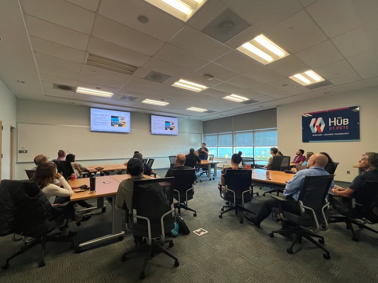 people sitting in a conference room watching a presentation